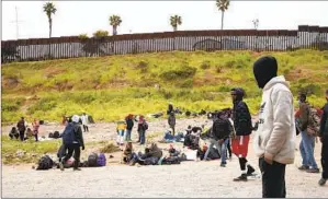  ?? ANA RAMIREZ U-T ?? Asylum seekers from various countries who had been apprehende­d by the Border Patrol appear between U.S.-Mexico border walls in San Diego on April 12.