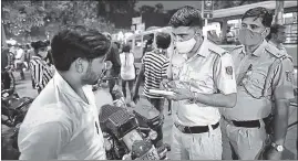  ?? AMAL KS/HT ?? A policeman fines a man for not wearing a mask in Govindpuri market on Wednesday.