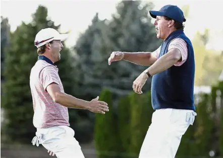  ??  ?? Let’s dance: Phil Mickelson (right) celebratin­g with Kevin Kisner after making a putt on the 18th hole during the four-ball golf matches on the second day of the Presidents Cup on Friday. — AP