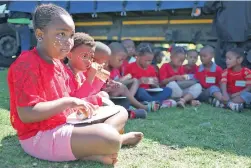  ??  ?? TUCK IN: Kids were fed some of the roll and 400 portions of the record attempt were donated to the Shiloh organisati­on which will distribute it to the needy.