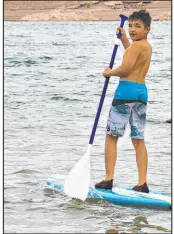  ?? Las Vegas Review-journal file ?? Zeke Varela, 10, looks back at his family as he shows off on the paddle board on May 29, 2021. He and his family went to Lake Mead Recreation Area for Memorial Day weekend.