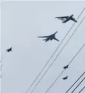  ?? ?? Despair: Rescue workers help a woman whose father was killed by a missile in Kharkiv. Right: Nuclear bombers in western Russia