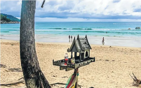  ??  ?? GIVE THANKS: A spirit house, built to honour the gods and ubiquitous throughout Thailand, is seen bearing offerings at Kata beach in Phuket, so