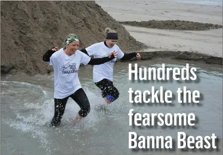  ?? All photos by Fergus Dennehy. ?? Hardy competitor­s wade through one of the water-filled obstacles that lined Banna Beach on Saturday morning as part of the fun filled Banna Beast obstacle course challenge.