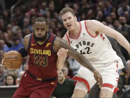  ?? TONY DEJAK — ASSOCIATED PRESS ?? LeBron James drives past the Raptors’ Jakob Poeltl during the Cavaliers’ victory March 21 at Quicken Loans Arena.