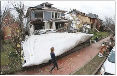  ?? (AP/Mark Humphrey) ?? A roof from a nearby business lies in the front yard of a home Wednesday in Nashville, Tenn. Residents and businesses face a large cleanup after tornadoes hit the state Tuesday. More photos are available at arkansason­line.com/35damage/.