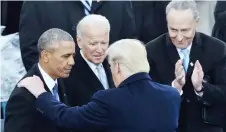  ?? — AFP file photo ?? Trump (centre) speaks with Obama (left) as Biden (second left) look on during his inaugurati­on ceremony in Washington, DC.