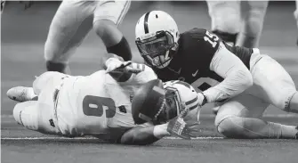  ?? MIKE DE SISTI / MILWAUKEE JOURNAL SENTINEL ?? Wisconsin running back Corey Clement and Penn State defensive end Torrence Brown watch a fumble by Clement bounce away from them in the second quarter.