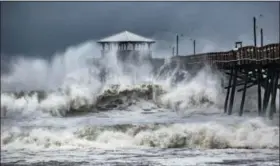  ?? TRAVIS LONG — THE NEWS & OBSERVER VIA AP ?? Waves slam the Oceana Pier &amp; Pier House Restaurant in Atlantic Beach, N.C., Thursday as Hurricane Florence approaches the area.