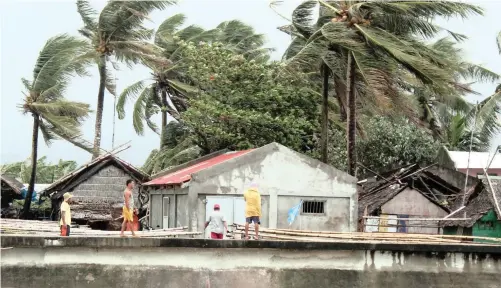  ??  ?? VILLAGERS view strong winds lashing trees next to houses in the town of Calabanga, Camarines sur province, Philippine­s. A weather forecast said a typhoon signal was raised in eastern Philippine­s as Typhoon Kammuri heads towards the main island of Luzon, warning residents living along its path to take precaution­ary measures. | EPA