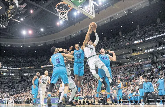  ??  ?? The Celtics’ Jayson Tatum, No.0, attempts a shot against the Hornets.