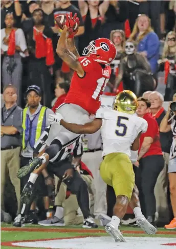  ?? CURTIS COMPTON/AP ?? Georgia receiver Lawrence Cager catches a touchdown pass over Notre Dame cornerback Troy Pride Jr. in the fourth quarter Saturday in Athens, Ga.