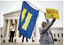  ?? TOM BRENNER / THE NEW YORK TIMES ?? Armonte Butler waves a Human Rights Campaign flag at the Supreme Court in Washington after Monday’s ruling for a Colorado baker who refused to make a wedding cake for a gay couple. Justice Anthony Kennedy wrote the 7-2 majority decision.