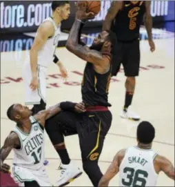  ?? PHIL LONG — THE ASSOCIATED PRESS ?? Cleveland’s LeBron James (23) drives to the basket against Boston’s Terry Rozier (12) and Marcus Smart (36) during Game 6 of the Eastern Conference finals Friday in Cleveland.