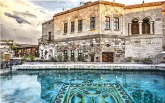  ??  ?? Antique luxury is found throughout the property — from 30 natural rock-cave suites, to Lil’a Restaurant, to the pool with breathtaki­ng views of Cappadocia.