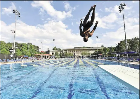  ?? HYOSUB SHIN / HSHIN@AJC.COM ?? A swimmer jumps off the diving board at the Emory Aquatics Center at the Student Activity and Academic Center in this file photo from last year. The Aquatics Center at the Student Activity and Academic Center is a premier outdoor swimming facility...