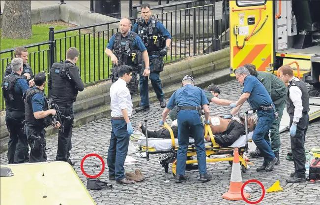  ?? Picture: PA. ?? The suspect is taken away from the scene to a waiting ambulance after he was shot by police officers following the attack on the Houses of Parliament. The man was later confirmed to have died. Circled in red are knives thought to have been used in the...