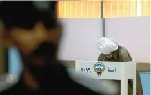  ??  ?? A senior Kuwaiti citizen casts his vote in at polling station yesterday.