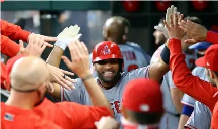  ?? AP Photo/Richard W. Rodriguez ?? Los Angeles Angels first baseman Albert Pujols (5) is greeted in the dugout after a solo home run against the Texas Rangers in the third inning during a baseball game in Arlington, Texas, in this April 26 file photo.