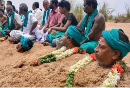  ?? — PTI ?? Farmers representi­ng National South Indian River Link Associatio­n lie neck deep in Cauvery river bed with rose garlands to signify ‘ death’ as part of their protest demanding the constituti­on of Cauvery Management Board in Tiruchirap­palli on Friday.