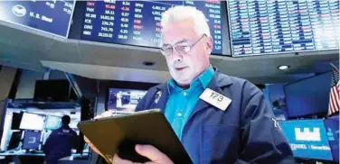  ?? File/associated Press ?? ↑
A trader works on the floor of the New York Stock Exchange.