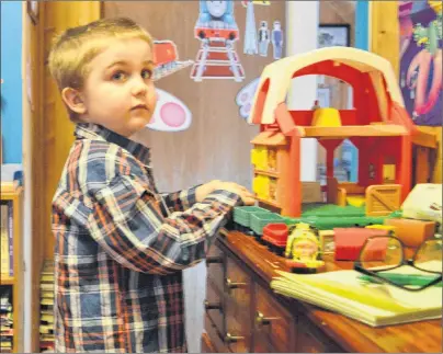  ?? NIKKI SULLIVAN/CAPE BRETON POST ?? Emmett Cormier puts together a toy train while watching “‘Thomas the Tank Engine” in his bedroom. He loves trains and puzzles —only five, he can already quickly put together a 100-piece puzzle.