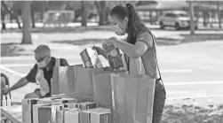  ?? JOHN RAOUX/AP ?? Volunteers package up personal protective equipment items to be handed out to small businesses Wednesday in Orlando, Fla.