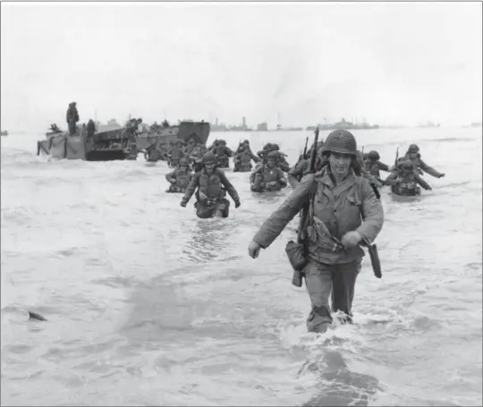  ?? BERT BRANDT — THE ASSOCIATED PRESS ?? U.S. infantryme­n wade through the surf as they land at Normandy in the days following the Allies' June 6, 1944, D-Day invasion of Nazi-occupied France.