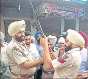  ?? HT PHOTO ?? Cops check a rifle left behind by the gang members involved in the shootout at Goindwal Sahib in Tarn Taran on Monday.