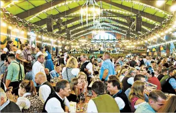  ?? RICK STEVE/RICK STEVES’ EUROPE PHOTOS ?? With over 7 million visitors each year, Munich’s Oktoberfes­t is a beer-fueled frenzy of music and amusement-park rides.