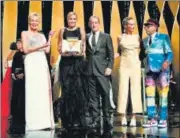  ??  ?? French director Julia Ducournau (centre) poses on stage after her win for Titane in Cannes on Sunday.