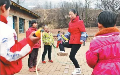  ?? PENG ZHAOZHI / XINHUA ?? A teacher plays with students at a school in Xihaigu in the Ningxia Hui autonomous region, the first poverty-stricken area visited by Xi in 1997.