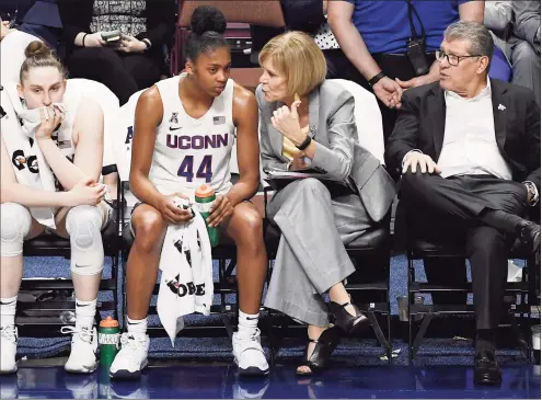  ?? Jessica Hill / Associated Press ?? UConn’s Aubrey Griffin (44) talks with associate head coach Chris Dailey as head coach Geno Auriemma, right, and Anna Makurat, left, watch play during an AAC Tournament quarterfin­al game against Temple in 2020.