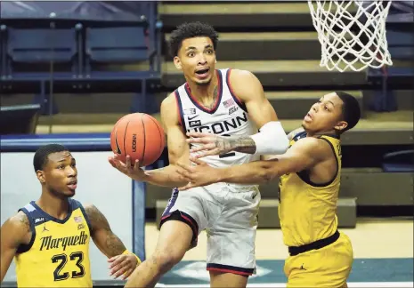  ?? David Butler II / USA Today Sports ?? UConn guard James Bouknight is fouled by Marquette guard Greg Elliott, right, in Saturday’s game at Gampel Pavilion in Storrs.