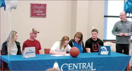  ?? MARK HUMPHREY ENTERPRISE-LEADER ?? Lincoln senior Kendra Cummings (center) signs a national letter of intent to play women’s college basketball for Central Baptist College, of Conway, on Thursday. She was accompanie­d by her family and friends from left: teammate Darrian McConnell, her...