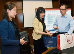  ??  ?? Working together: Fu (right) handing over a souvenir to Zhou (centre). With them is SAPPRFT Internatio­nal Cooperatio­n Department officer Cao Zhi Xin.