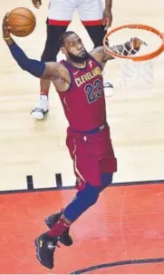  ?? The Canadian Press ?? LeBron James dunks against the Raptors during the first half of Game 1 of the Eastern Conference semifinals on Tuesday. He delivered a triple-double in the Cavaliers’ 113-112 OT win.