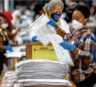  ?? STEVE SCHAEFER FOR THE AJC ?? DeKalb County electionwo­rkers in Stonecrest sort presidenti­al election ballots as part of the statewide recount by hand of the vote Saturday.