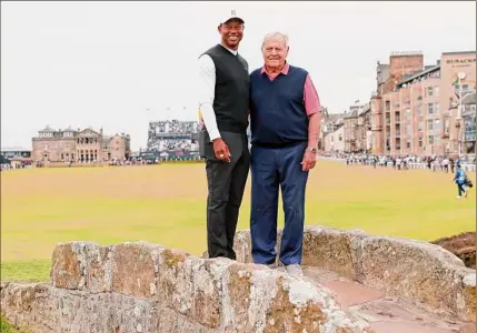  ?? Peter Morrison / Associated Press ?? Tiger Woods, left, and Jack Nicklaus pose for a photo on the Swilcan Bridge at the Old Course at St. Andrews in Scotland on Monday. Woods will be competing in the 150th British Open that begins Thursday morning.