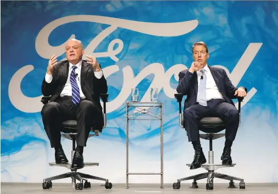  ?? PAUL SANCYA/THE ASSOCIATED PRESS ?? Jim Hackett, Ford Motor Co.’s newly named chief executive, left, speaks with Bill Ford Jr., executive chairman., in Dearborn, Mich., on Monday.