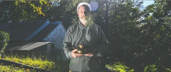  ?? RICKY CARIOTI/ THE WASHINGTON POST ?? Martin Goldsmith holds the 16th-century kettle that belonged to his grandparen­ts before they died at the hands of the Nazis in the Second World War.