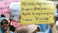  ?? BOY SLAMET/JAWA POS ?? DEMI JALAN: Selain membawa peralatan dapur, dalam aksinya kemarin (23/2) puluhan ibu membentang­kan poster bernada protes keras.