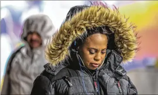 ?? JOHN SPINK / AJC ?? Eva Harden braved the cold outside the North Avenue MARTA Transit Station in midtown Atlanta Tuesday. Forecaster­s have warned that it will be dangerousl­y cold today. The mountain counties could get 1 to 3 inches of snow and metro Atlanta could get...
