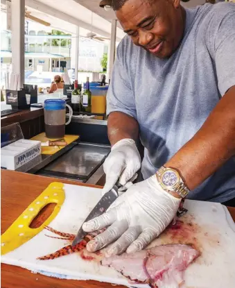  ??  ?? Above: lionfish being prepared. Below: in the Bahamas, local fishermen are paid to drop off lionfish for the Cape Eleuthera Institute.