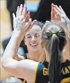  ?? Ronald Cortes The Associated Press ?? Iowa freshman guard Caitlin Clark high fives a teammate as she heads to the bench during Tuesday’s NCAA Tournament game against Kentucky. Clark scored 35 points in the game, including 24 in the first half.