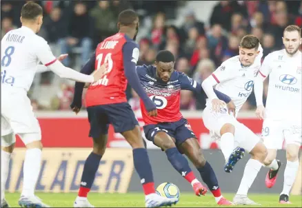  ?? (AP) ?? Lille’s Jonathan Bamba, (center), controls the ball during his French League One soccer match between Lille and Lyon at the Lille Metropole Stadium in
Villeneuve d’Ascq, northern France, on March 8, 2020.