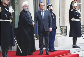  ??  ?? Below: former French President François Hollande (right) welcomes Iranian President Hassan Rouhani