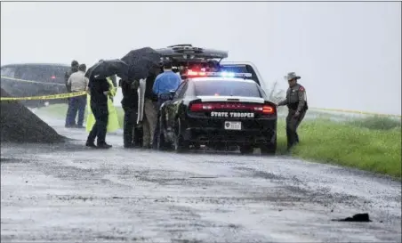  ?? DANNY ZARAGOZA — THE LAREDO MORNING TIMES VIA AP ?? Law enforcemen­t officers gather near the scene where the body of a woman was found near Interstate 35 north of Laredo, Texas on Saturday. A U.S. Border Patrol agent suspected of killing four women was arrested early Saturday after a fifth woman who had been abducted managed to escape from him and notify authoritie­s, law enforcemen­t officials said, describing the agent as a “serial killer.”