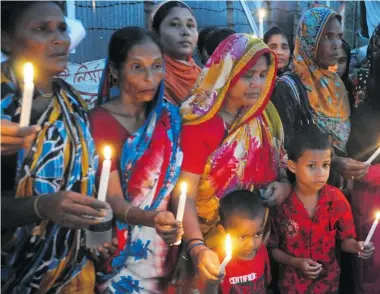  ?? SUVRA KANTI DAS/AFP/Getty Images ?? Bangladesh­i garment workers and relatives of victims of the Rana Plaza building collapse gather for a memorial at the site
of the Rana Plaza garment factory building collapse on Thursday, the six-month anniversar­y of the disaster.