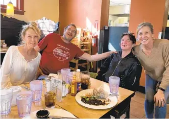  ?? COURTESY MARY BENIRSCHKE ?? Walk With Me participan­ts Teri Jasper (far left) and Cindy Braun (far right) with a homeless couple.